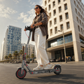 Femme roulant en ville sur la trottinette électrique Daiko Move grise
